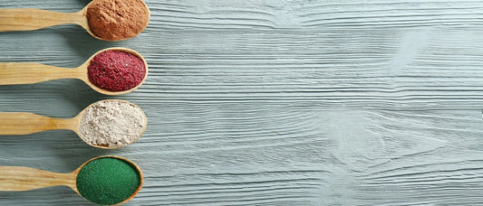 Chlorella powder and other supplements in wooden spoons