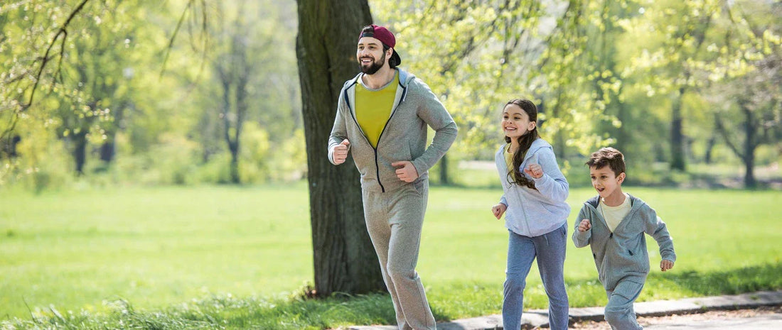 Father and kids run happily in the park