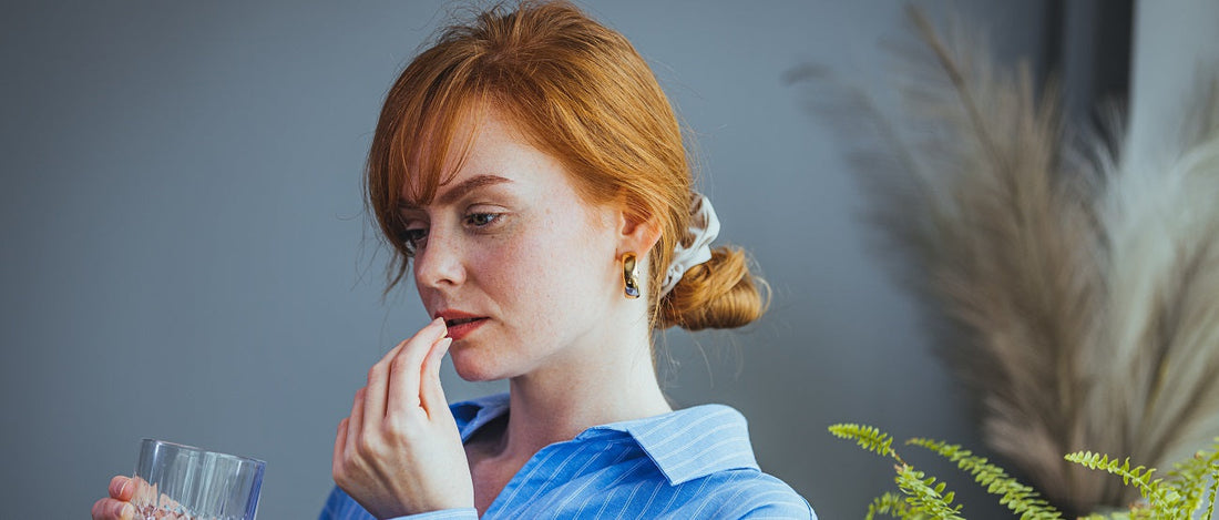 Girl taking supplements with a glass of water