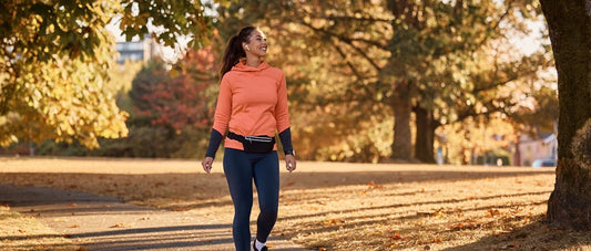 Happy woman walking in the park during autumn