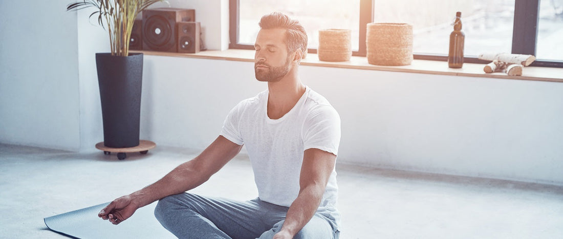 Man relaxing and practicing meditation in the living room