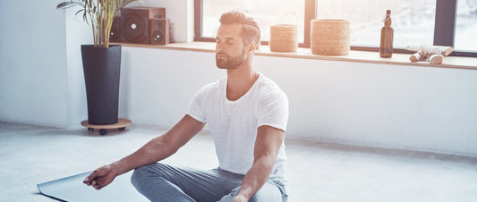 Man relaxing and practicing meditation in the living room