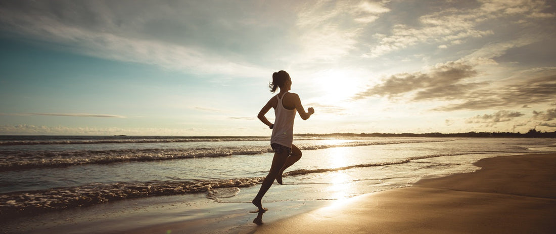 Woman running in the beach during sunset