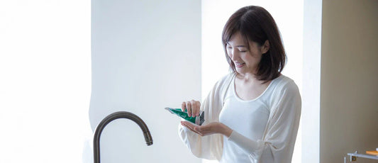 Woman taking chlorella tablets in the kitchen