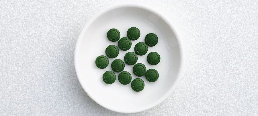 Chlorella tablets on a green dish