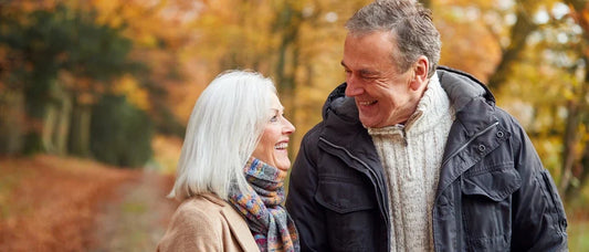 senior couple walking outdoors in nature, representing long-term vitality and healthy daily routines